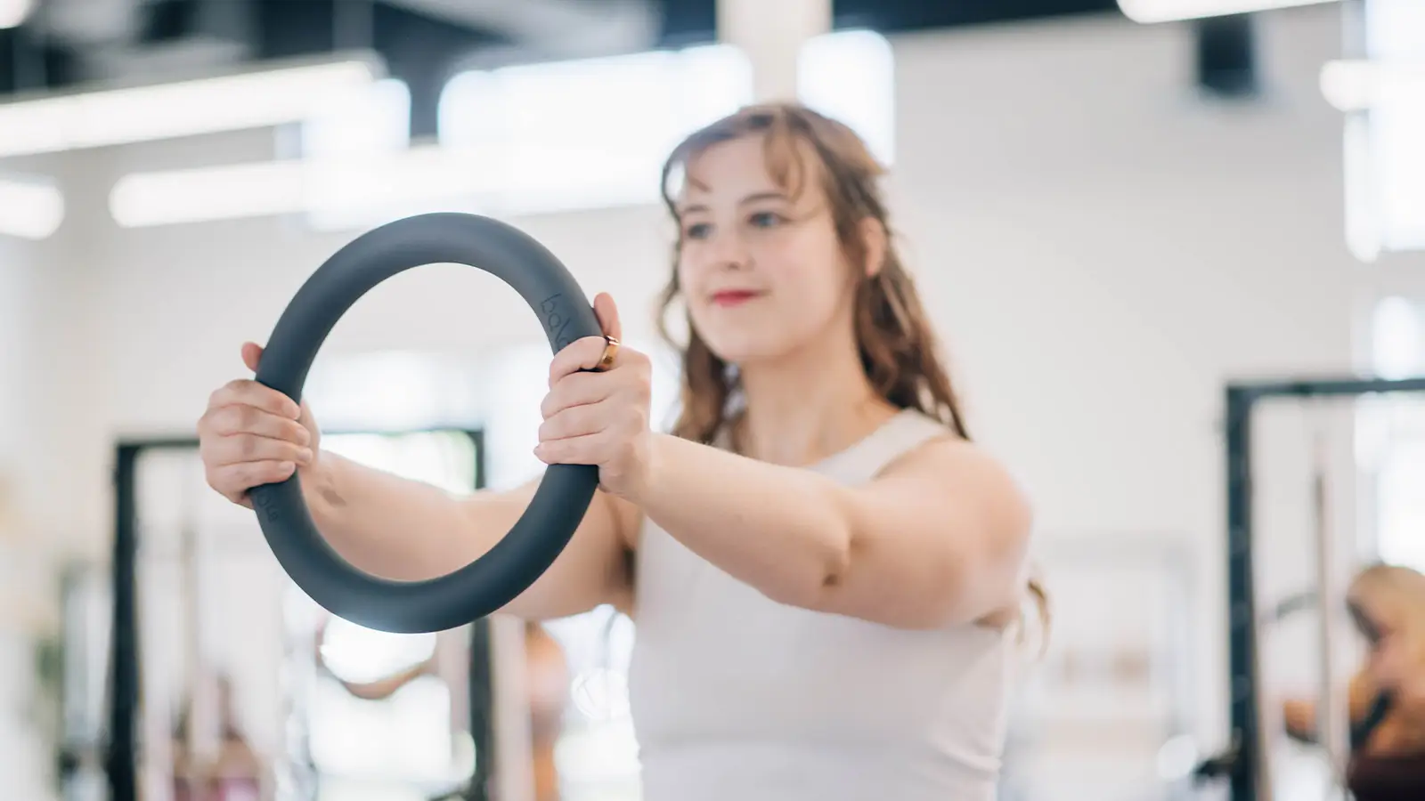Pilates instructor holding a magic circle in a bright studio